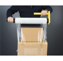Mann verpackt Kartons mit einer Hand Stretchfolie mit Griff.