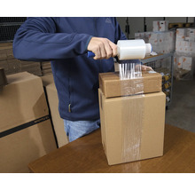 Homme emballant des cartons avec du film étirable