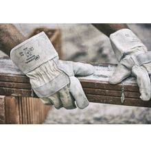 Gebol Worker Schutzhandschuhe aus Leder beim Heben eines Ziegelsteins