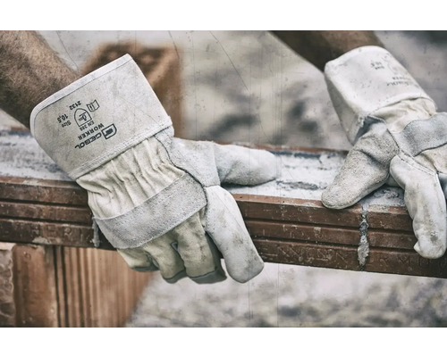 Gebol Worker Schutzhandschuhe aus Leder beim Heben eines Ziegelsteins