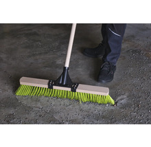 Balai avec manche en bois et poils colorés en utilisation