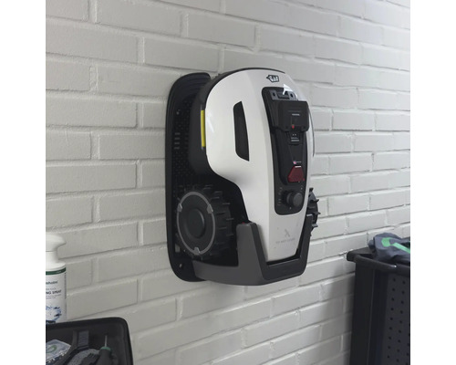 Wandmontierter Mähroboter an einer Backsteinmauer