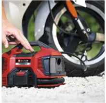 Compresseur sans fil rouge Einhell devant une moto
