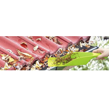 Reinigung einer Dachrinne mit einer Schaufel zum Entfernen von Blättern