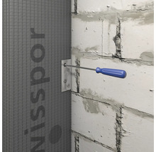 Installation einer Bauplatte mit Schrauben und Schraubenzieher an einer Mauer