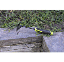 Laub- und Gartenrechen mit Zinken und Kunststoffgriff auf Steinmauer