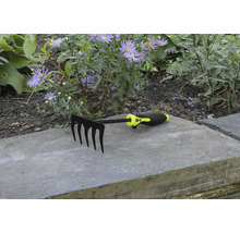 Gartenrechen mit fünf Zinken vor Blumenbeet