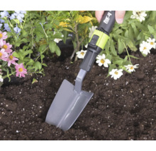 Eine Hand nutzt eine for_q Pflanzkelle zum Graben in Erde in einem Blumenbeet.