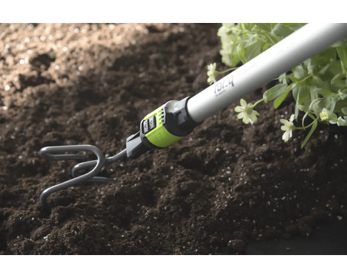 Griffe de jardin avec manche ameublissant la terre à côté de plantes.
