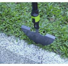 Coupe-bordure utilisé sur une bordure de pelouse entre herbe et chemin pavé.