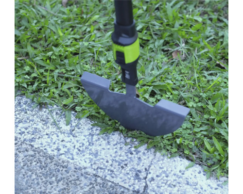 Coupe-bordure utilisé sur une bordure de pelouse entre herbe et chemin pavé.