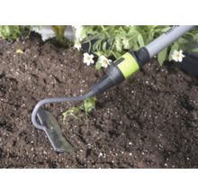 Binette de jardin en métal lors du travail de la terre à côté d une plante.
