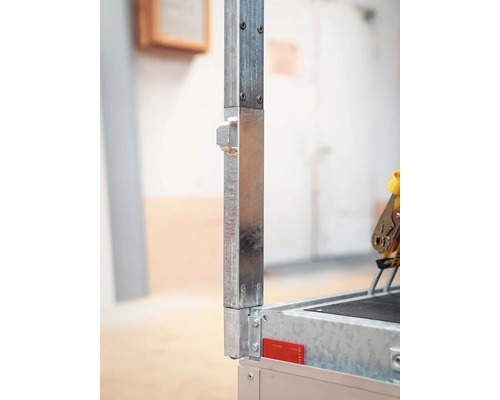 Detailaufnahme eines verzinkten Metallpfostens an einem Anhänger mit Befestigungsöse und Bolzen.