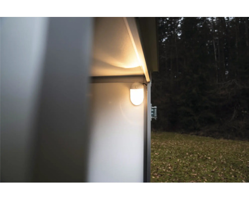 Éclairage intérieur LED brillant monté sur la paroi à l'intérieur d'un abri de jardin en métal dans un jardin.