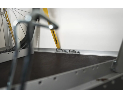 Anneaux d'arrimage sur la paroi latérale d'une remorque pour fixer un vélo avec une sangle.