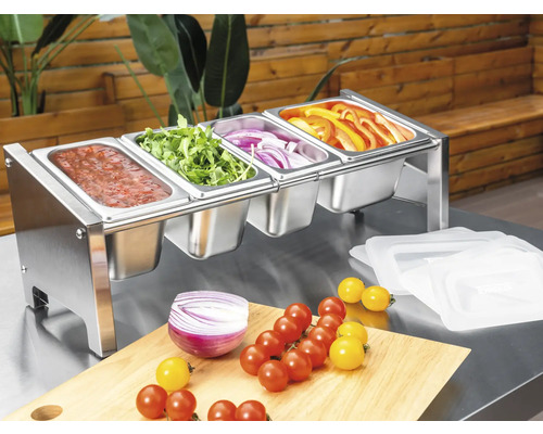 Support de bacs Gastronorm en acier inoxydable à quatre compartiments, rempli de légumes frais et de sauce sur une table de travail.