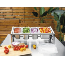 Station d'ingrédients en acier inoxydable avec quatre bacs Gastronorm remplis de légumes et sauce sur une table en métal avec planche à découper.