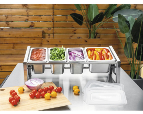 Station d'ingrédients en acier inoxydable avec quatre bacs Gastronorm remplis de légumes et sauce sur une table en métal avec planche à découper.