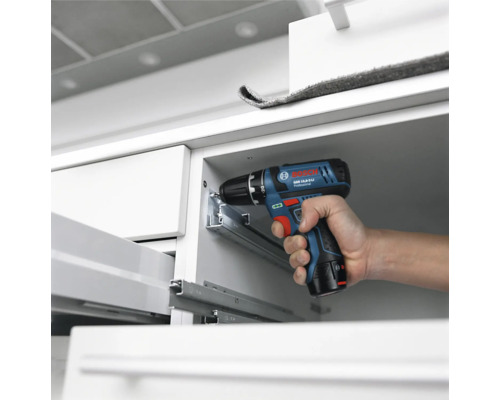 Bosch Professional Akku-Bohrschrauber bei der Montage von Metall-Schubladenschienen in einem weissen Schrank.