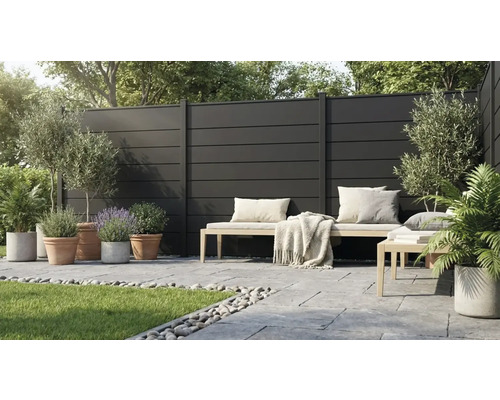 Brise-vue moderne composé de panneaux sombres sur une terrasse avec banc en bois, dalles en pierre et diverses plantes en pots.