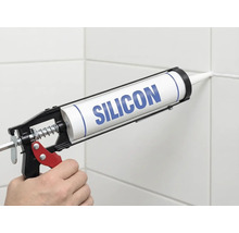 Anwendung von Silikon mit einer Kartuschenpresse an einer Fliesenfuge.