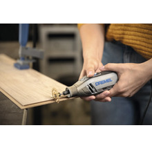 Outil multifonction Dremel 4250 avec disque à tronçonner coupant une planche en bois.