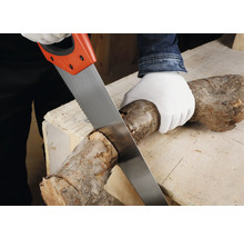 Eine Person sägt mit einem Fuchsschwanz einen Holzstamm auf einer Werkbank.