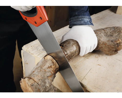 Eine Person sägt mit einem Fuchsschwanz einen Holzstamm auf einer Werkbank.