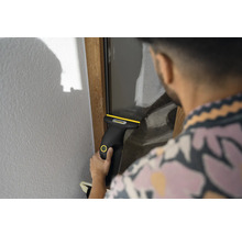 Personne nettoyant une vitre avec un nettoyeur de vitres sans fil Kärcher.