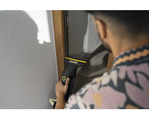 Personne nettoyant une vitre avec un nettoyeur de vitres sans fil Kärcher.