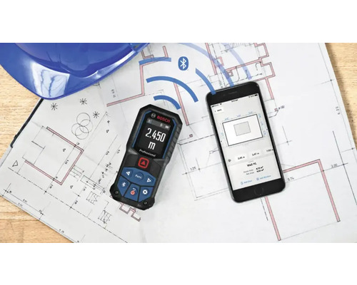 Télémètre laser Bosch avec connexion Bluetooth à une application smartphone sur un plan de construction.