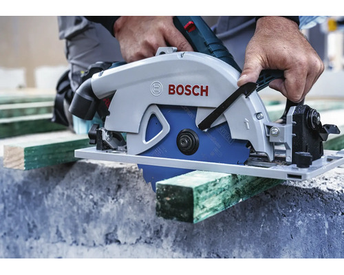 Handwerker sägt ein Holzbrett mit einer Bosch Handkreissäge auf einer Baustelle.