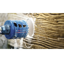 Scie cloche Bosch Expert Carbide Technology perçant un trou rond dans une surface texturée avec refroidissement par eau.