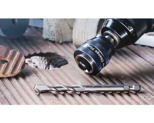 Adaptateur Power Change Plus sur une perceuse et un foret sur une surface en bois rainurée.