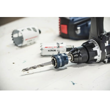Adaptateur Bosch Power Change Plus avec foret de centrage monté sur une perceuse-visseuse à côté de scies-cloches.
