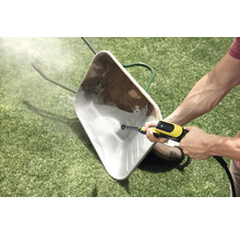 Nettoyage d'une brouette sale sur une pelouse avec un nettoyeur haute pression.