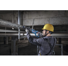 Artisan utilisant une scie sabre Bosch Professional pour couper un tuyau métallique sur un chantier.