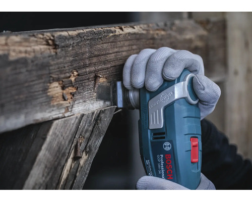 Outil multifonction sans fil Bosch Professional GOP 18V-34 en train de couper du vieux bois avec un accessoire Starlock Plus.