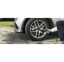 Eine Person pumpt mit der Bosch Akku-Druckluftpumpe EasyPump einen Autoreifen im Aussenbereich auf.