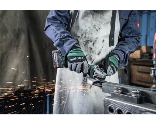 Person nutzt einen Metabo Akku-Winkelschleifer zur Bearbeitung eines Metallprofils in einer Werkstatt, Funkenflug.