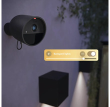 Caméra de sécurité Philips Hue Secure noire fixée au mur avec interface numérique pour commander les lumières extérieures.