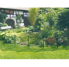 Grüner Metall-Steckzaun als Teichumrandung im Garten mit Pflanzen, Tontöpfen und einem Fachwerkhaus im Hintergrund.