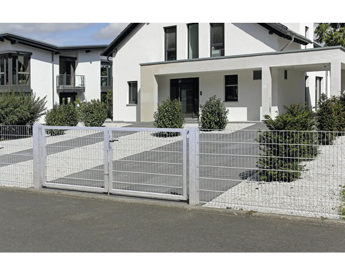 Portail à deux battants en treillis soudé et clôture assortie devant une maison moderne avec jardin de gravier et arbustes.
