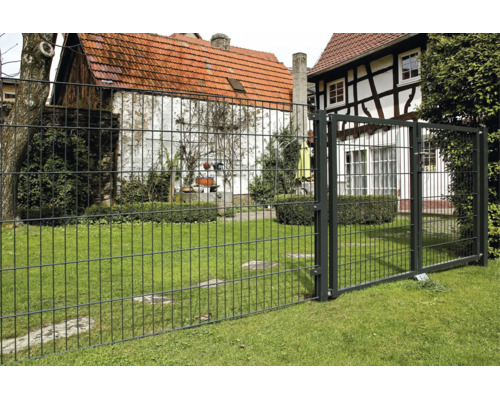 Clôture à double fil anthracite et portillon en métal dans un jardin lumineux et entretenu sur une pelouse.