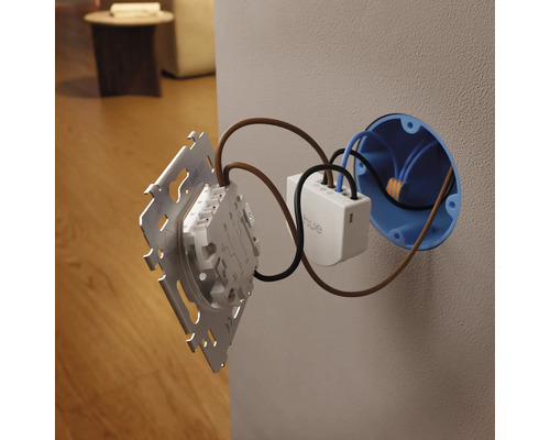 Module d'interrupteur mural Philips Hue lors de l'installation derrière un interrupteur dans une boîte d'encastrement.