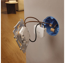 Module d'interrupteur mural Philips Hue avec Philips Hue Logo lors de l'installation dans une boîte d'encastrement avec câblage, bornes et plaque.