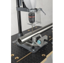 Support de perçage avec étau de machine fixant un tube métallique pour le perçage sur un établi.