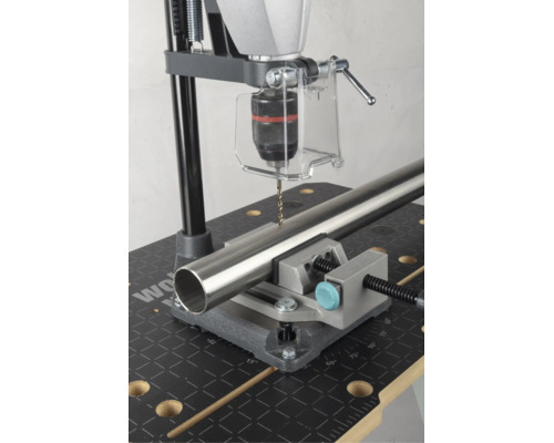 Support de perçage avec étau de machine fixant un tube métallique pour le perçage sur un établi.
