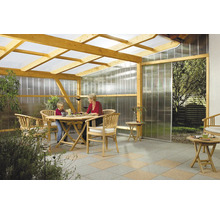 Toit de terrasse en bois avec plaques alvéolaires transparentes sur le toit et les parois, meublé de mobilier de jardin en bois sur dalles.