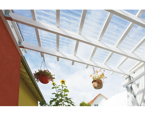 Terrassenüberdachung aus weißem Holz mit transparenten Wellplatten und hängenden Blumenampeln.